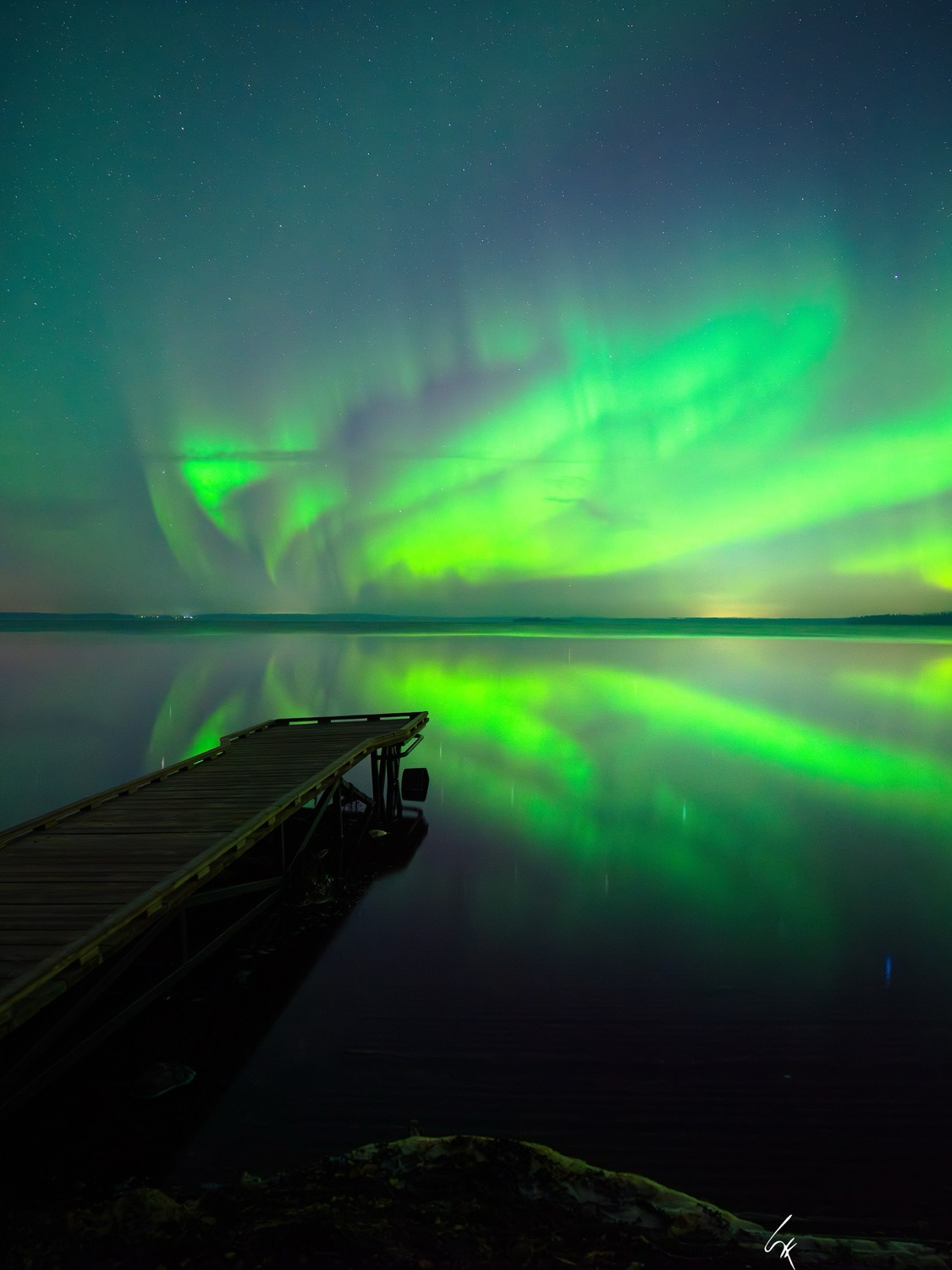 Auroras boreales danzando sobre un lago en Fort McMurray, Alberta