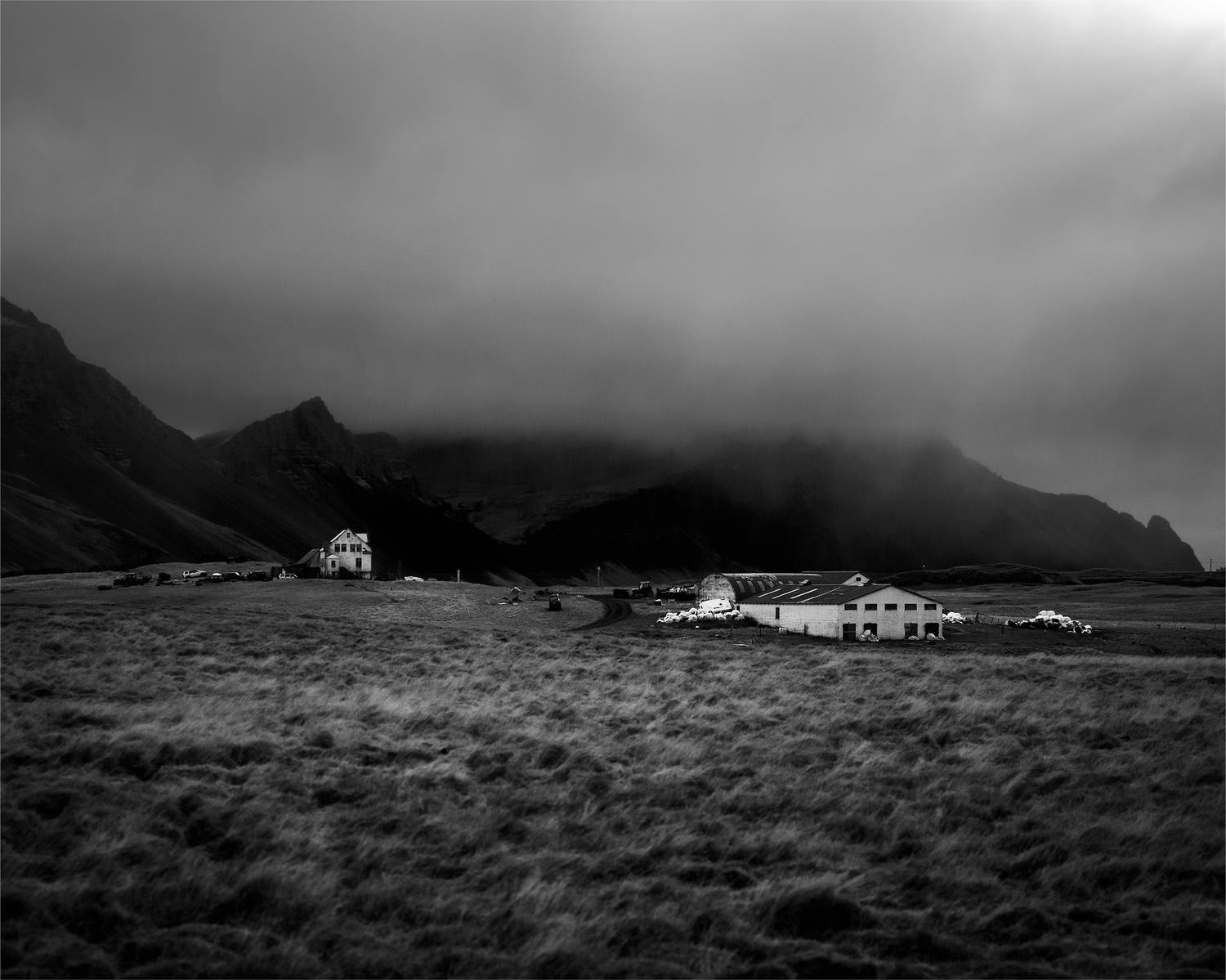 Granja islandesa bajo una nube de tormenta, en blanco y negro